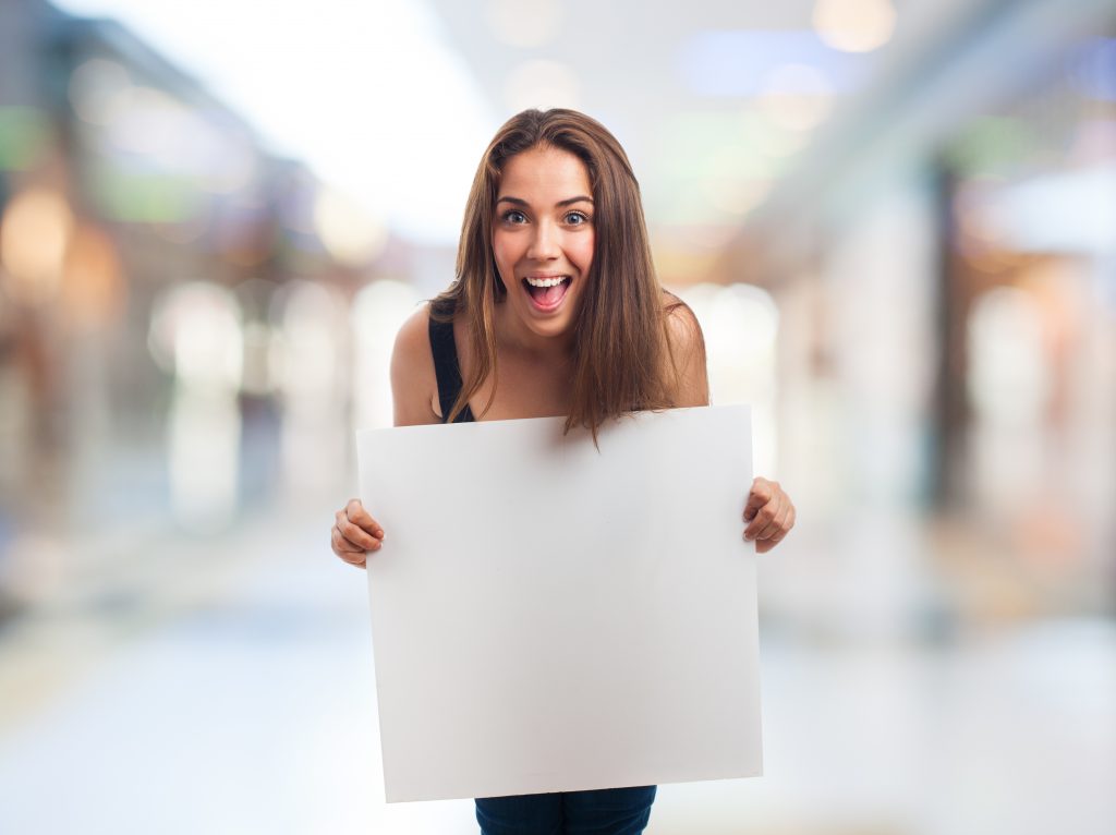 Happy young woman holding a white banner